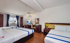 A hotel room with two beds, a desk, a chair, a TV, and a window with curtains.