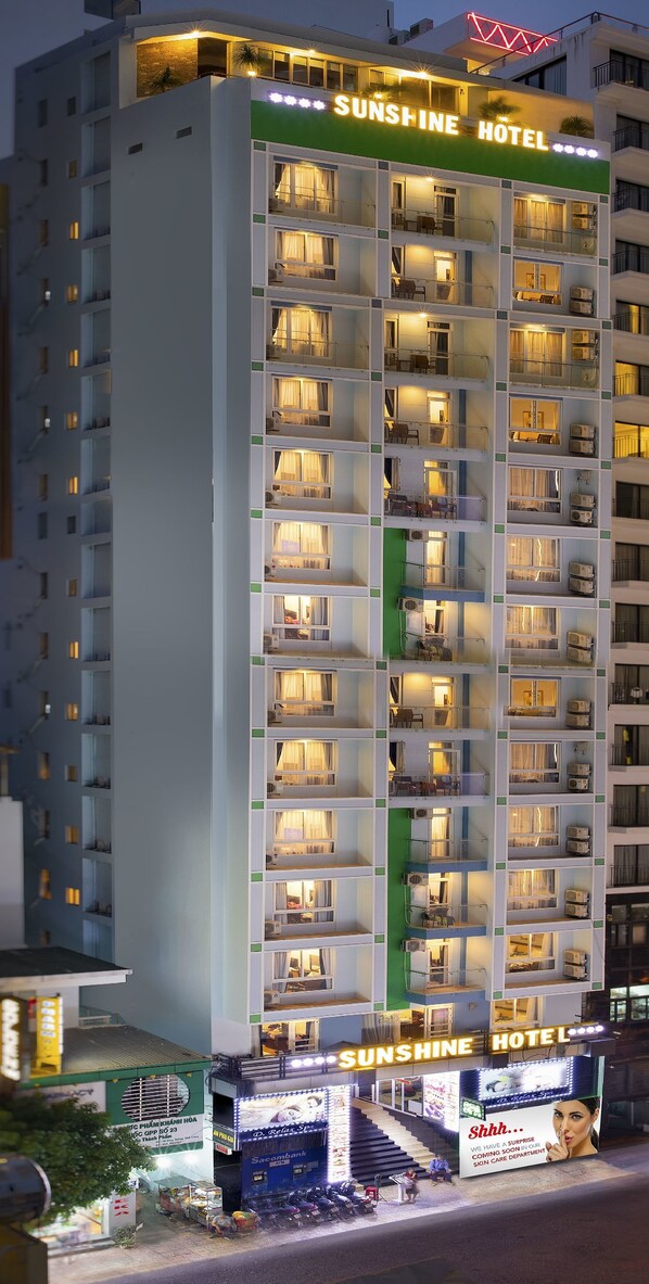 A multi-story hotel with balconies and a sign reading "Sunshine Hotel."