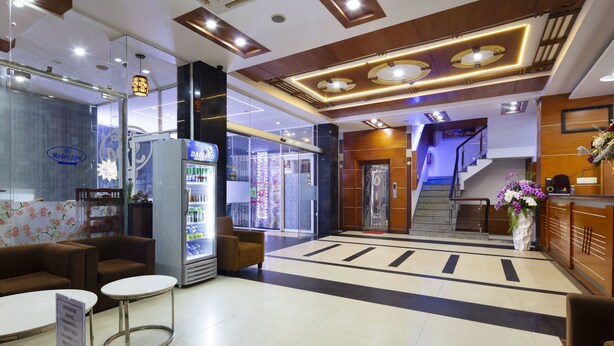A hotel lobby with a reception desk, seating area, and a staircase leading to the upper floors. - Sunshine Hotel Nha Trang (Nha Trang)