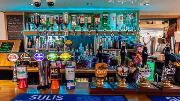 A bar area with multiple liquor bottles and a variety of beer taps. - The Beacon Inn (Stonehouse)