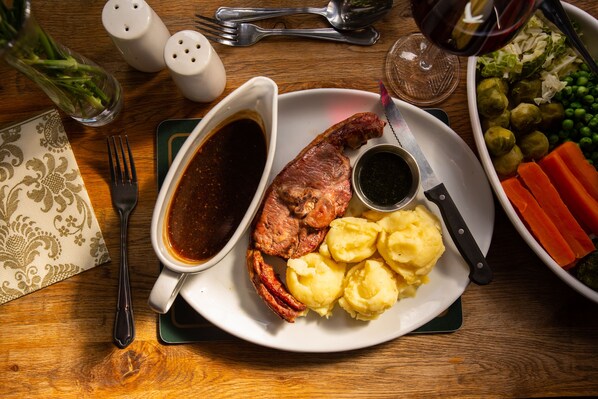 A plate of food with gravy, mashed potatoes, and carrots.