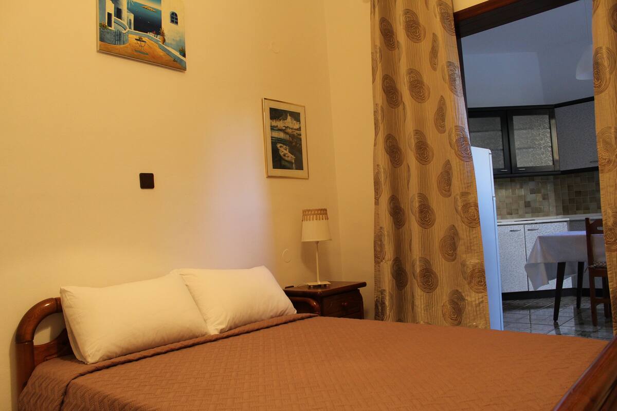 Une chambre à coucher avec un lit, une table de chevet, une lampe et un tableau au mur.
