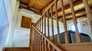Una escalera de madera con barandilla que sube a un nivel superior.