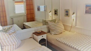 Una camera d'albergo con un letto, un comodino, tende e uno specchio.