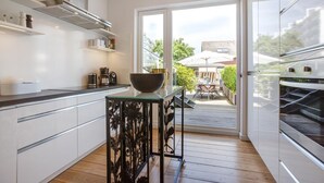 A modern kitchen with white cabinets, a glass-top island, and stainless steel appliances. - The locksmith's shop awarded 5 stars according to DTV (Westerland)