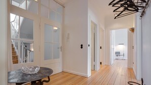 A spacious hallway with wooden flooring, white walls, and a staircase leading to upper floors. - The locksmith's shop awarded 5 stars according to DTV (Westerland)