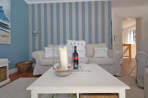 Relax in style with a comfortable sofa, coffee table, and elegant striped wallpaper.