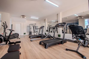 A gym with treadmills, elliptical machines, and weight benches. - Apartamentos Livvo Coloradamar (Yaiza)