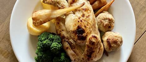 Une assiette composée de poulet rôti, de frites, de brocolis et d’une portion de chou rouge.