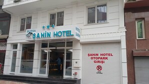 Un edificio con un cartel que dice "SAHIN HOTEL" y "OTOPARK".