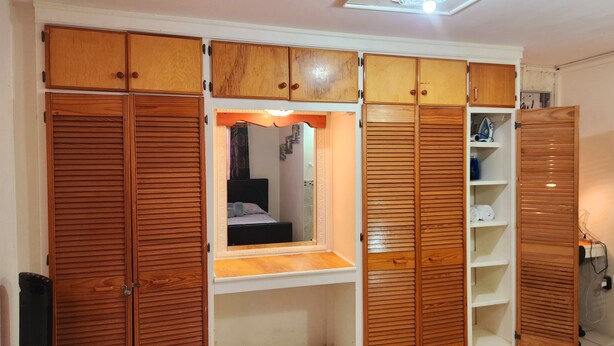 Ein Schlafzimmer mit Einbauschrank, Nachttisch und Spiegel.