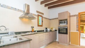 A modern kitchen with a stainless steel sink, wooden cabinets, a microwave, and a built-in oven. - VILLA FRONTERA - Villa with private pool and views to the mountains in Soller Free WiFi (S��ller)