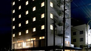 Un hotel de varios pisos con ventanas iluminadas y un diseño arquitectónico moderno.