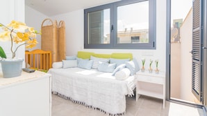Een slaapkamer met een bed, nachtkastje en een raam.