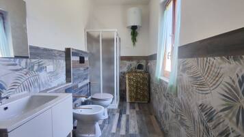 Een bad/douchecombinatie, een haardroger, een bidet, handdoeken