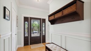 A hallway with a wooden bench, a dark door with stained glass, and a wall-mounted wicker shelf. - Luxury Home a Short Walk to Beach and Town with Amazing Reviews  (Point Pleasant Beach)