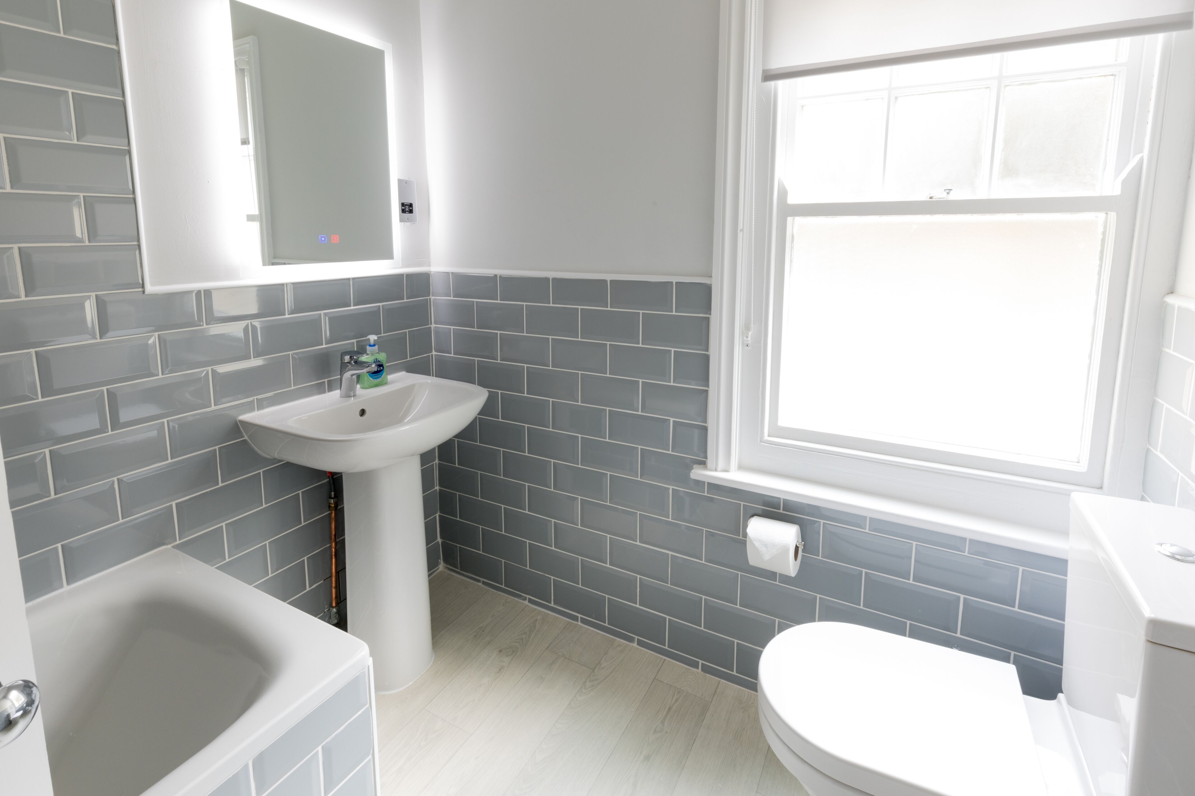 A bathroom with a white sink, a toilet, and a bathtub.