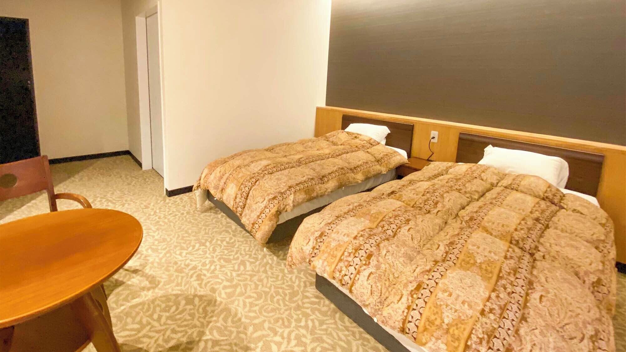 A hotel room with two beds, a wooden chair, and a large mirror.