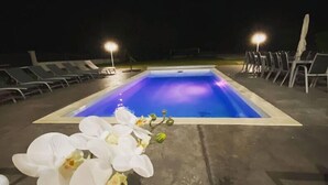 Une piscine avec des chaises longues et une composition florale.