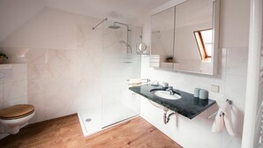 Un baño moderno con ducha, inodoro y lavamanos.
