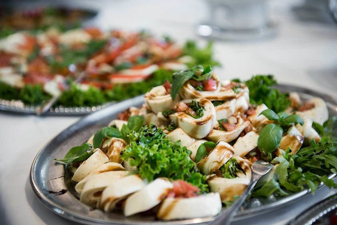 A plate of food with sliced vegetables and herbs.