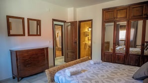 Ein Schlafzimmer mit Bett, Kommode und Kleiderschrank.