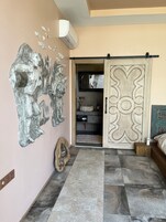 A room with a large decorative wall piece, a sliding door with intricate patterns, and a tiled floor.