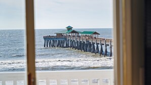 A pier extending into the sea with a building at the end.