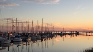 Un port de plaisance où de nombreux bateaux sont amarrés sur une étendue d’eau calme qui reflète le ciel.