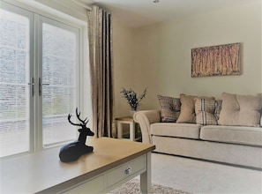 Relax in this inviting living room with a comfortable sofa, decorative deer head, and a piece of abstract art.