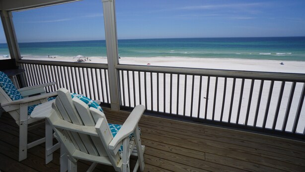 A covered deck with white chairs and a view of a beach. - Beach front home perfect for a family or couple.  Amazing view. (Port St Joe)