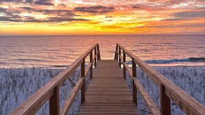 A wooden boardwalk leading to a beach with a sunset in the background. - Beach front home perfect for a family or couple.  Amazing view. (Port St Joe)