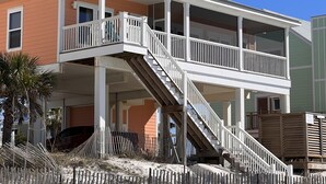 A two-story house with a covered porch and a staircase leading to the upper floor. - Beach front home perfect for a family or couple.  Amazing view. (Port St Joe)
