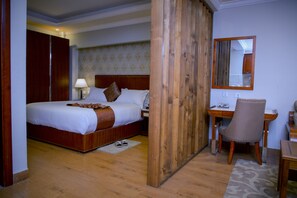 A hotel room with a wooden bed, a desk, and a chair. - Mosy Hotel (Addis Ababa)