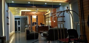 A modern hotel lobby with a reception desk, seating area, and a chandelier. - Mosy Hotel (Addis Ababa)