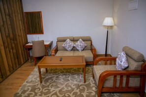 غرفة ديلوكس | منطقة المعيشة | تلفزيون بشاشة مسطحة بحجم 32-بوصة يعرض قنوات تلفزيونية رقمية، تلفزيون