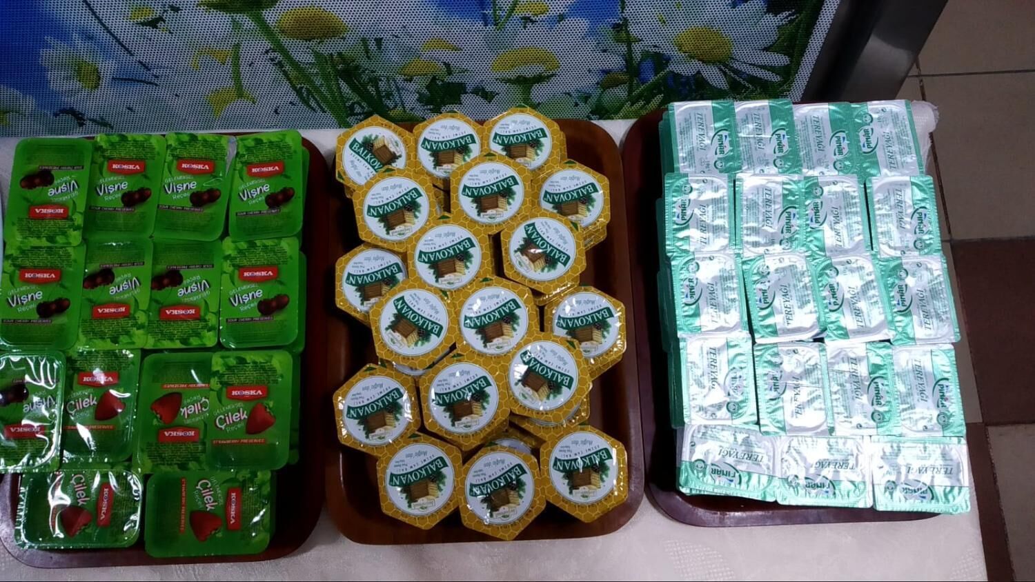 A display of packaged food items, including green and yellow packages with labels, arranged on a table.
