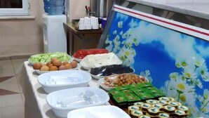 Una mesa de buffet con diversos alimentos y un cuadro de flores.