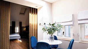 Habitación moderna con comedor, cama y vista al exterior.