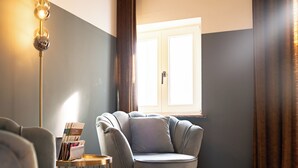 Una sala de estar moderna con un sofá gris, una mesita redonda y una lámpara de pie.