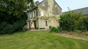 A stone house with a garden in front. - Les Tisserands (La Cambe)