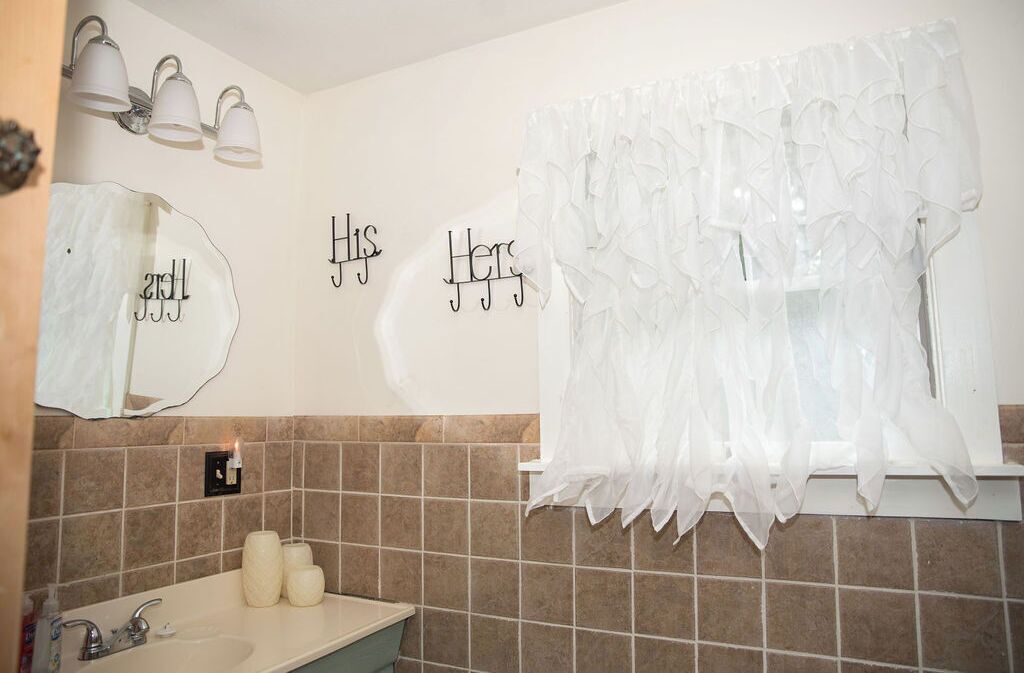 A bathroom with a sink, mirror, and decorative wall lights.