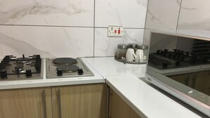 A kitchen with a gas stove, a built-in oven, and a microwave. There are cabinets below the countertop.
