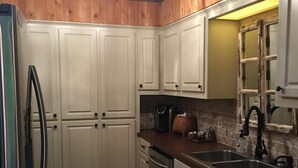 A kitchen with white cabinets, stainless steel appliances, and a wooden ceiling. - Natchez Trace Cabin Retreat on 5 acres (Canton)