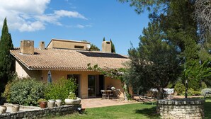 A house with a tiled roof, a garden with potted plants, and a stone wall. - Architect's Villa In The Heart Of The Vines Near Avignon (Châteauneuf-de-Gadagne)