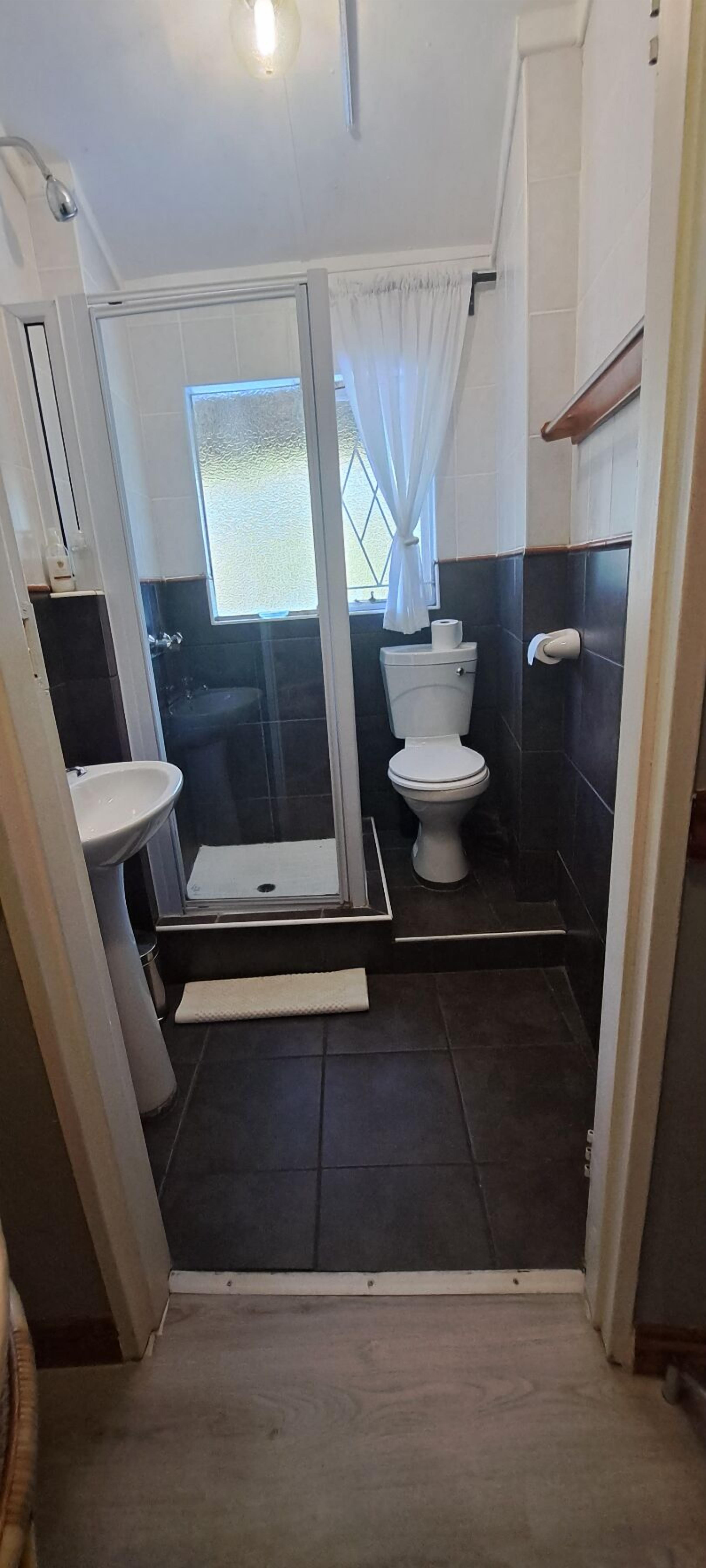 Un baño con ducha, inodoro y lavabo.