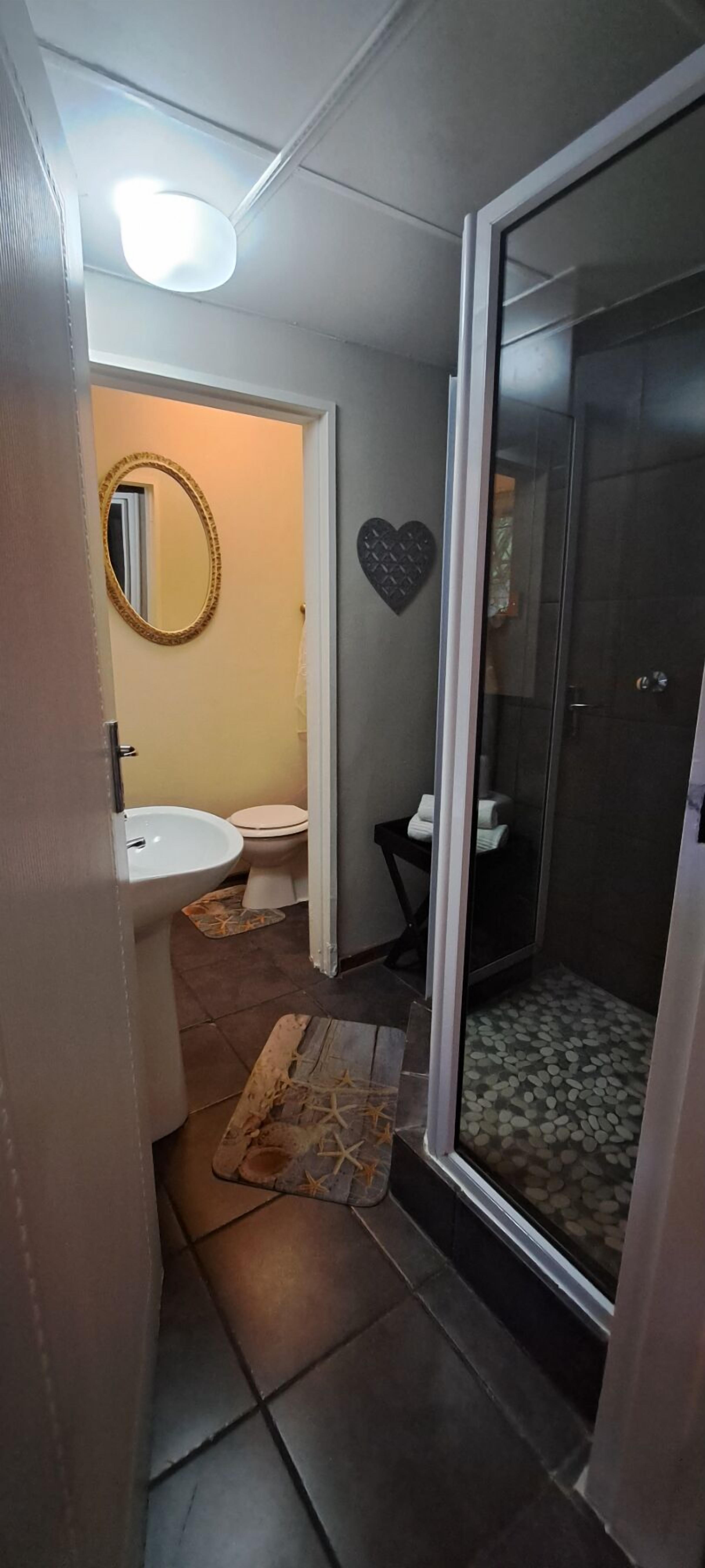 Un baño con ducha, lavamanos e inodoro.