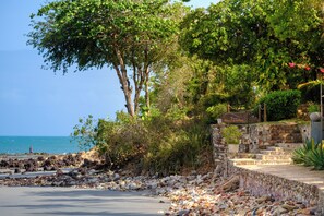 A coastal road with a stone wall and a sign reading "Jeriba". - Pousada Jeribá (Jijoca de Jericoacoara)