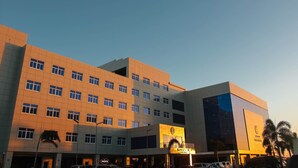 A multi-story hotel with a modern architectural design, featuring a prominent entrance and a large glass facade.