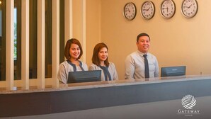 A reception area with a reception desk, three wall clocks, and pendant lighting.